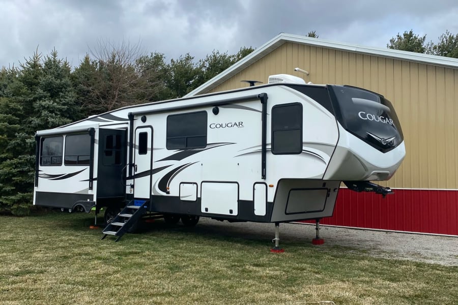 Exterior with 2 awnings with wind safe on them, lights, and outdoor speakers.