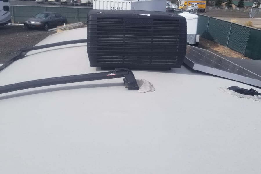 RV rental roof: Dometic AC unit, ProRac roof rack, and solar panels for your road trip comfort.