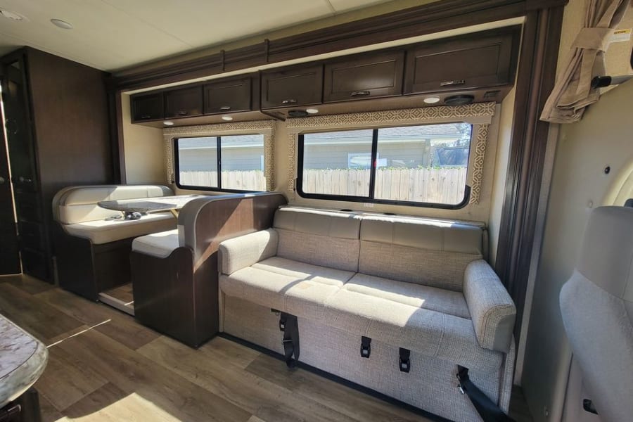 Experience comfort in this RV rental! Features include a dinette, sofa, overhead storage, and large windows. Ideal for road trips.