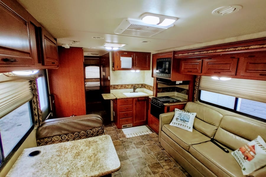 Step inside this RV rental! Features a complete kitchen, cozy living room, and dining area for your adventures.