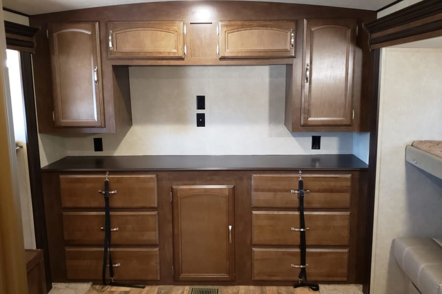 RV rental interior with built-in cabinetry, drawers, and counter, offering ample storage for a comfortable stay.