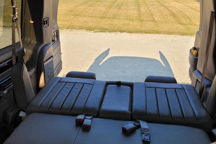 Explore comfort in this **rv rental**! View of grass/gravel from the interior featuring versatile leather seats converting to a bed.