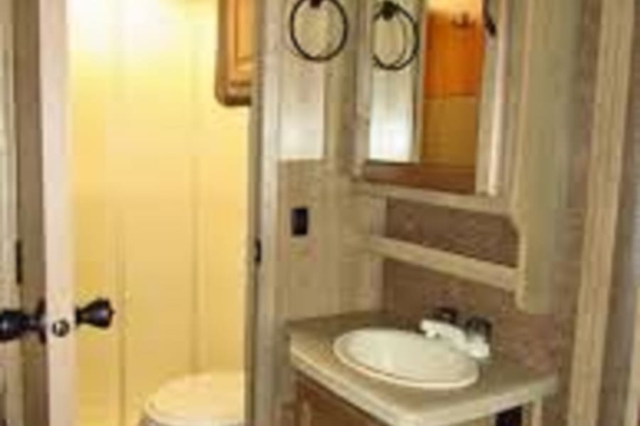 Full sized shower, bathroom, and vanity