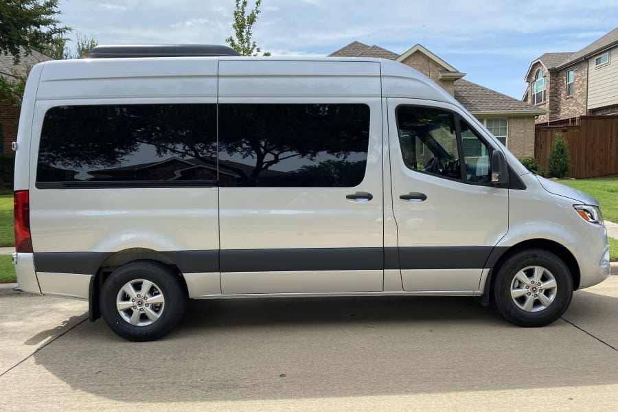 A silver Mercedes-Benz Sprinter van, excellent for rv rental, parked on a paved driveway.