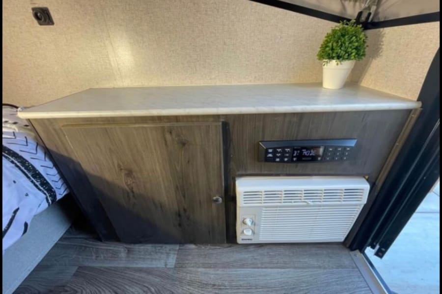 RV rental interior: Built-in counter, storage, AC unit, and control panel.