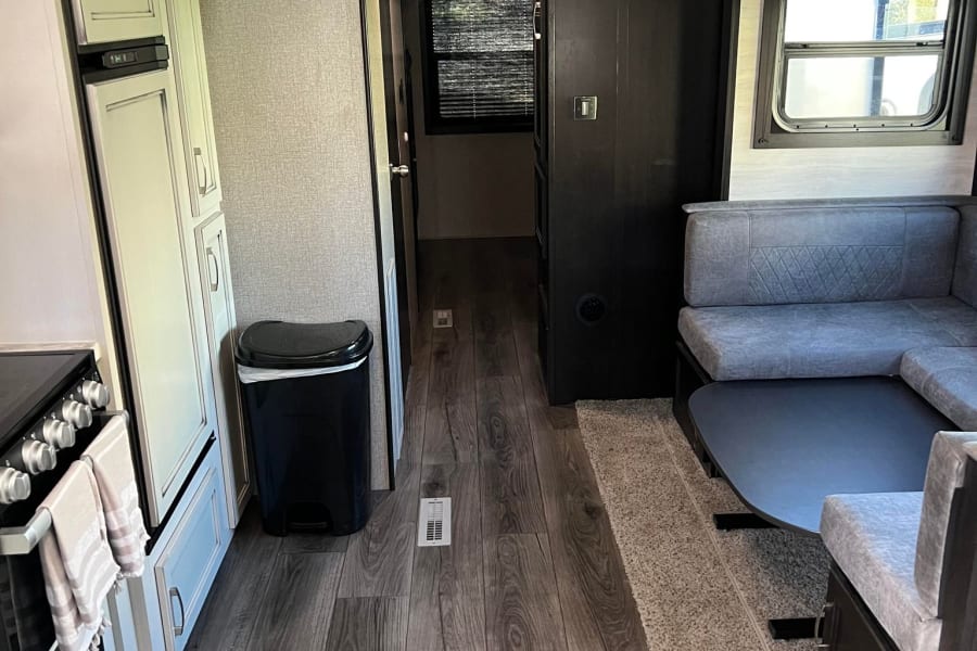 RV rental: Full view of an RV's kitchen, hallway, and living space with a comfy U-shaped dinette.