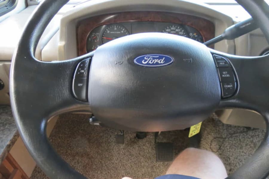 Driving an RV rental: view of the Ford steering wheel, dashboard with speedometer, and driver's leg.