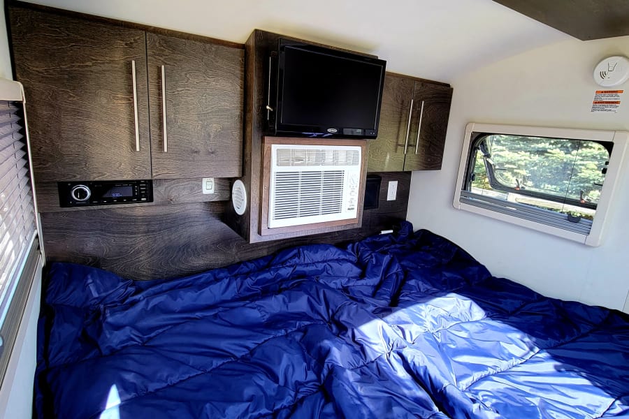 Queen bed, storage shelves and under mattress storage, AC, TV and indoor-outdoor stereo with Bluetooth, tons of internal lighting options!
