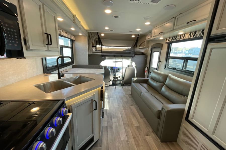 Step inside this modern RV rental! Features a full kitchen, comfy living area, and cab-over bunk bed.