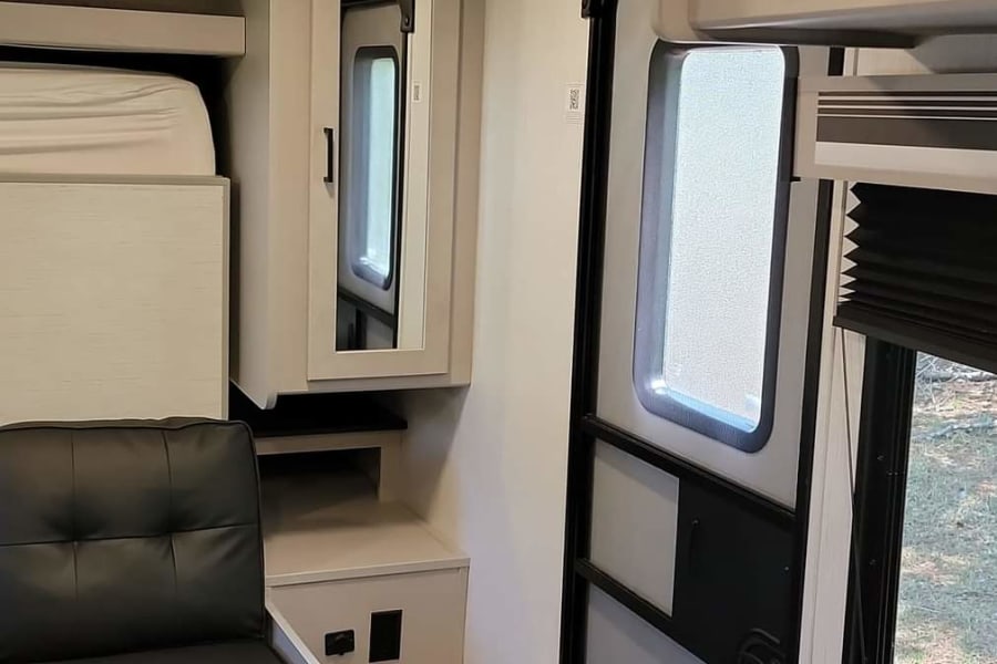 Spacious RV rental interior with dinette, bunk bed, and modern finishes for comfortable travel.