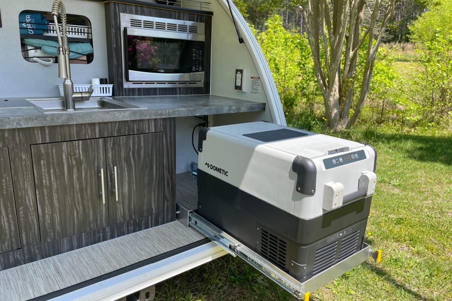 RV rental outdoor kitchen with sink, microwave, and Dometic pull-out fridge, ideal for convenient camping.