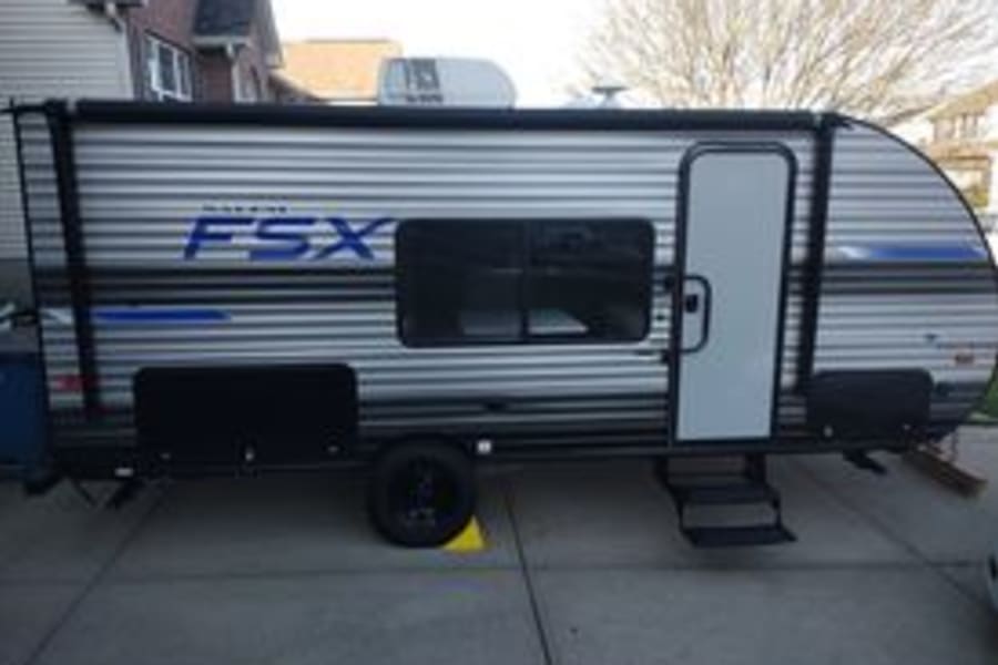 A silver and black FSX travel trailer, perfect for RV rental. Ready for camping & travel adventures.