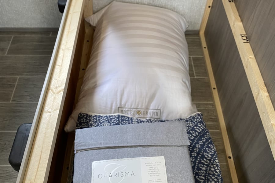 Pillow, sheets, and fuzzy blanket provided for the dinette sleeper.