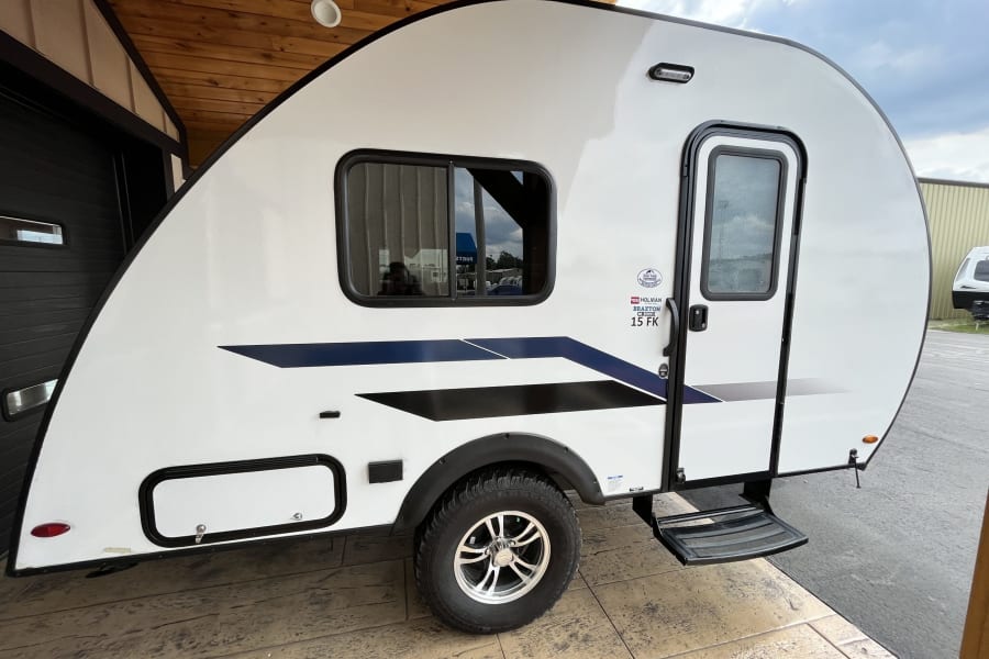 White Braxton Creek 15 FK travel trailer with black/blue graphics, ideal for your next RV rental.