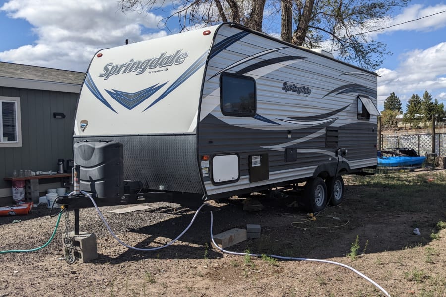 Springdale RV rental parked with hookups, providing temporary outdoor living.