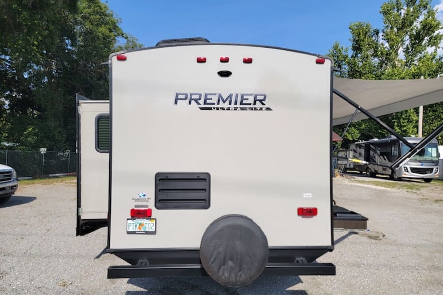 Rear view of a Premier Ultra-Lite travel trailer, an excellent RV rental option. Note the rear-mounted spare tire.