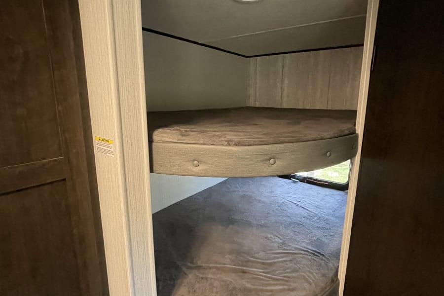 Cozy RV rental interior featuring comfortable bunk beds for extra sleeping space in your camper or travel trailer.