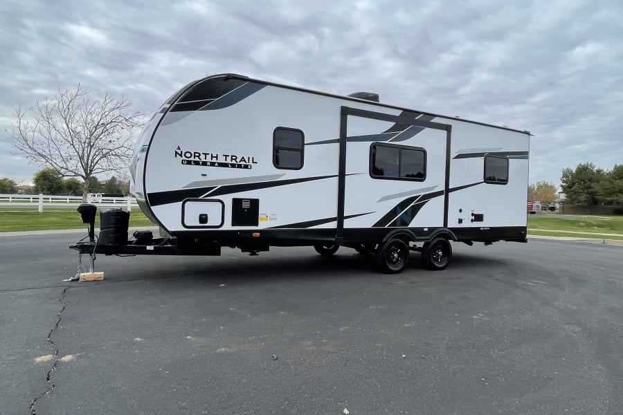 Modern North Trail Ultra Lite travel trailer parked, ideal for your next RV rental adventure.