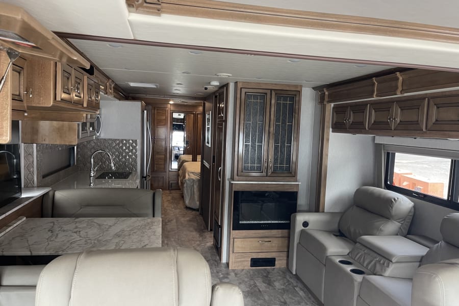 Spacious RV rental interior with modern kitchen, living area, and bedroom for comfortable travel.
