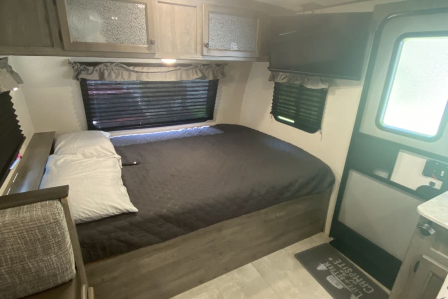 Queen bed with SmartTV on adjustable mount above. 