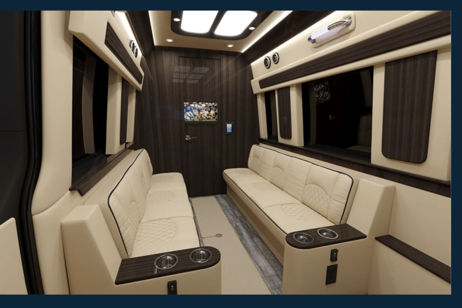 Step inside this upscale rv rental. Features a spacious interior with facing cream leather sofas, wood paneling, and entertainment.