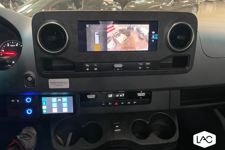 RV rental dashboard displays 360&deg; parking assist on the main screen, alongside climate, media, and custom controls below.