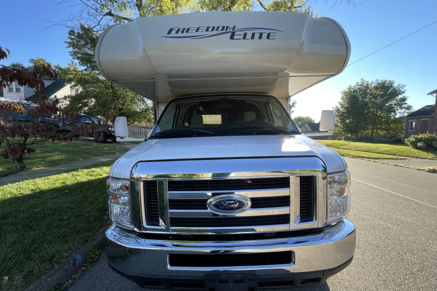 Front view of a white Freedom Elite Class C Ford rv rental, parked on a sunny day, ready for adventure & travel.