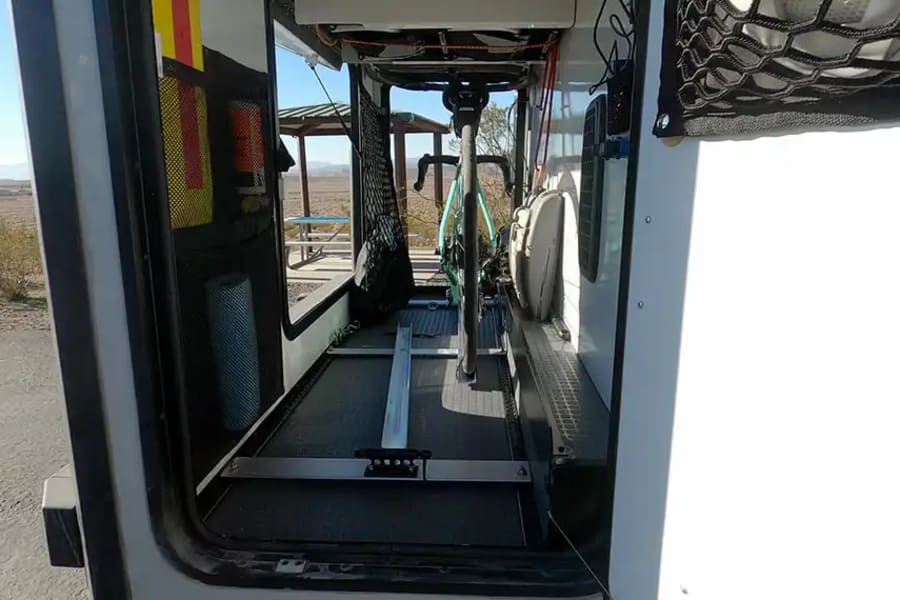 This RV rental's organized interior shows a bike mounted on a track, plus adventure gear storage.