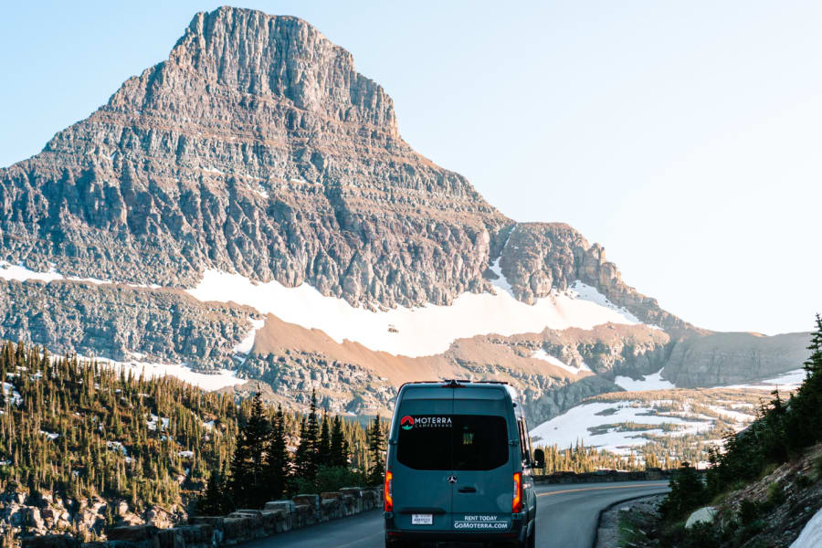 Grey Moterra campervan on a winding mountain road with snow. Your next RV rental adventure awaits here.