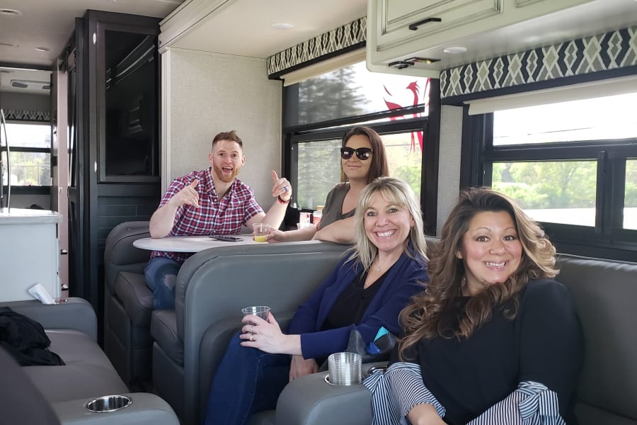 Group of friends relaxing inside a comfortable RV rental, showcasing the cozy interior for travel adventures.