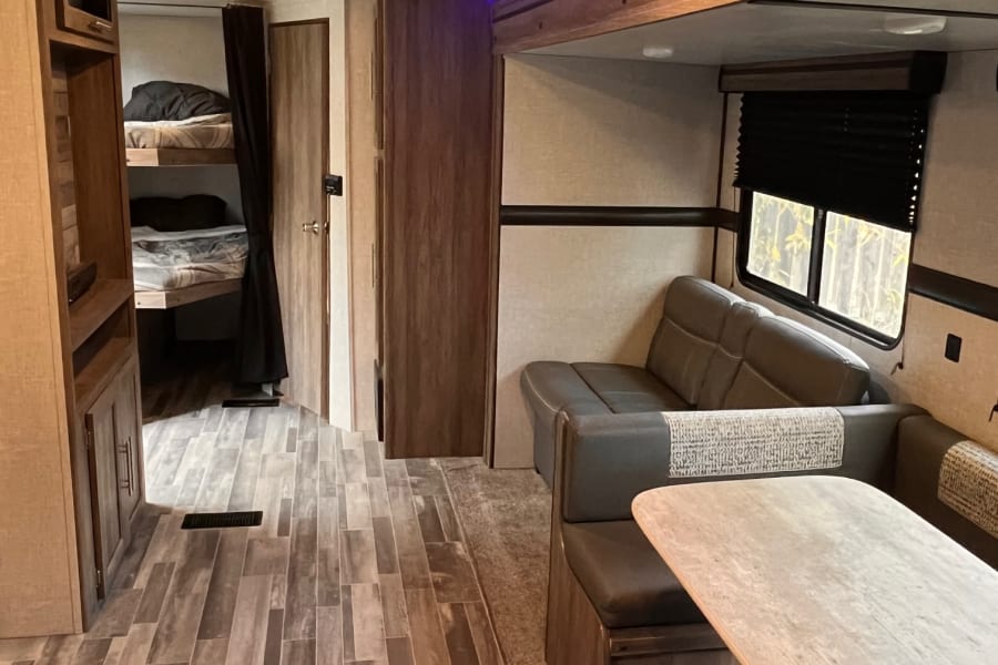 Step inside this RV rental! Features a comfortable dinette, functional kitchen counter, and sleeping berths with ambient blue LED light.