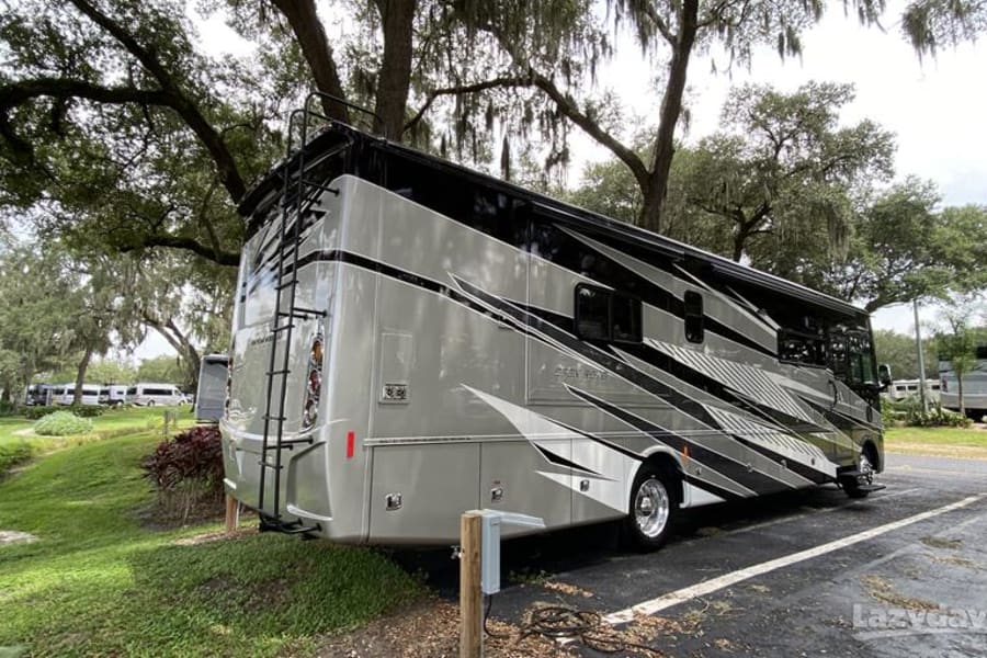 Spacious Class A RV rental parked in a shaded campsite. Ready for your next motorhome adventure and travel.