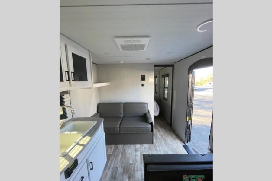 Experience this RV rental's spacious interior with a full kitchen, comfortable living area, and inviting layout. Perfect for travel!
