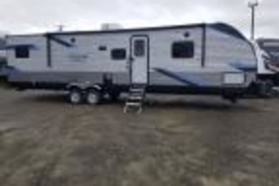 Large white & blue travel trailer. Perfect RV rental for your next camping adventure and travel.