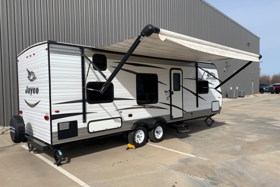 This white and grey Jayco travel trailer RV rental, with awning extended, is ready for your next road trip!