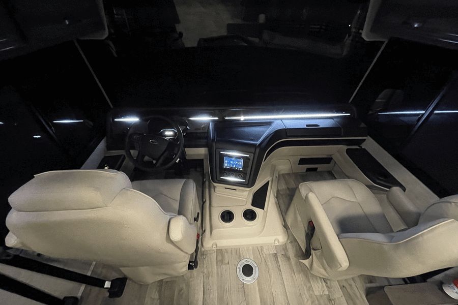 Get a look inside an RV rental! This image shows the spacious, modern cockpit with light-colored seats and a digital dashboard.