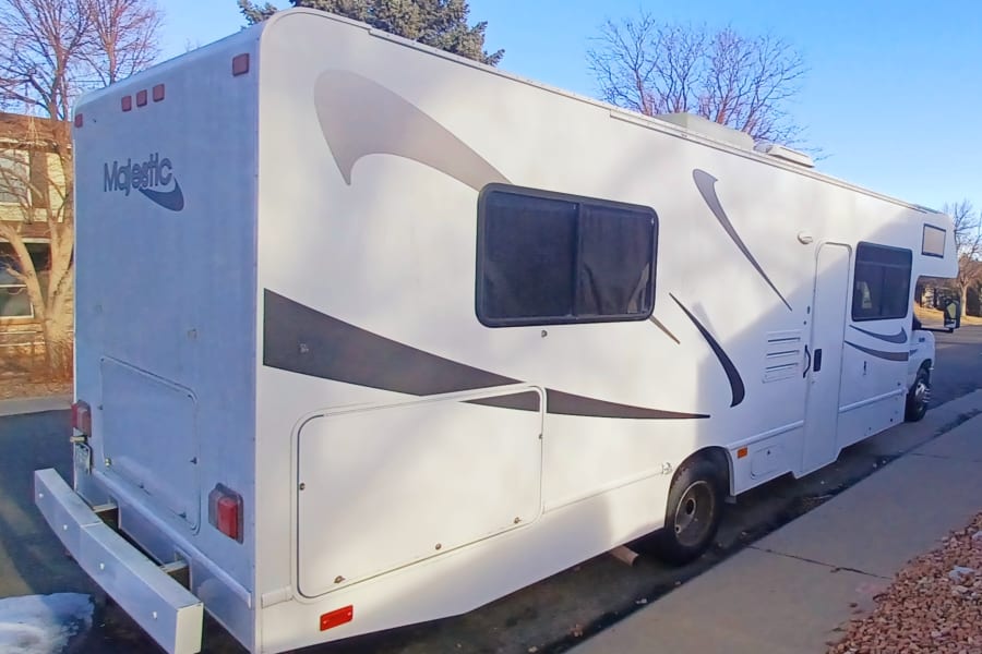 This white Majestic Class C RV rental is parked outside with gray decals.
