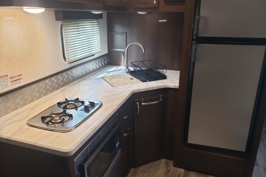 there is a flat screen tv over the fridge not in picture.  2 burner stove, microvave/oven.  Dual deep sinks.