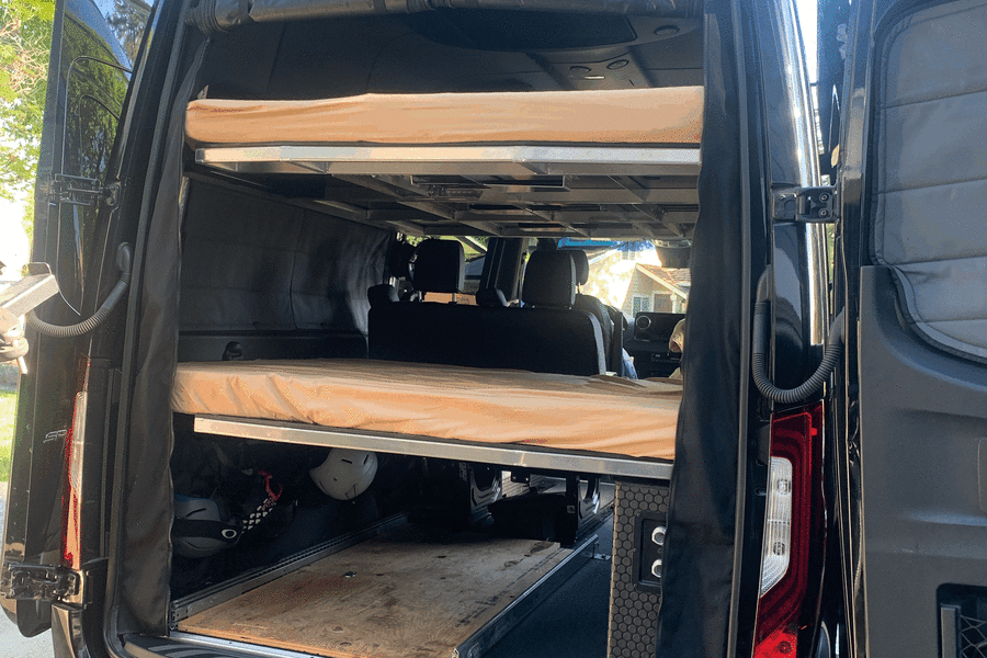 Spacious RV rental camper van with dual bunk beds, solar panels, and pull-out gear storage for adventure.