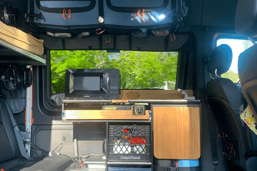 This RV rental interior offers a compact kitchenette, cooler, portable power, and smart storage for your adventures.