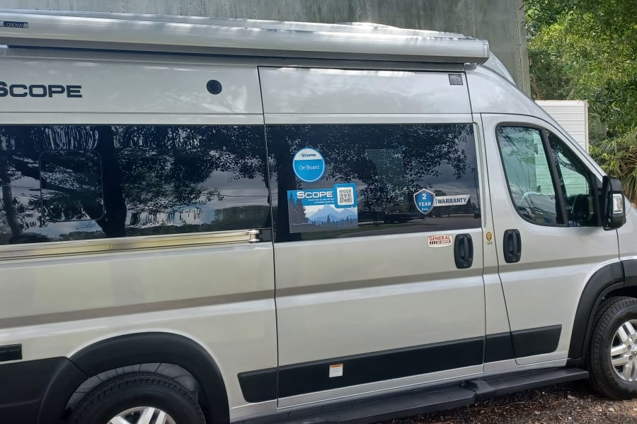 This silver "SCOPE" camper van is an ideal RV rental, equipped with a Thule awning and Truma system.