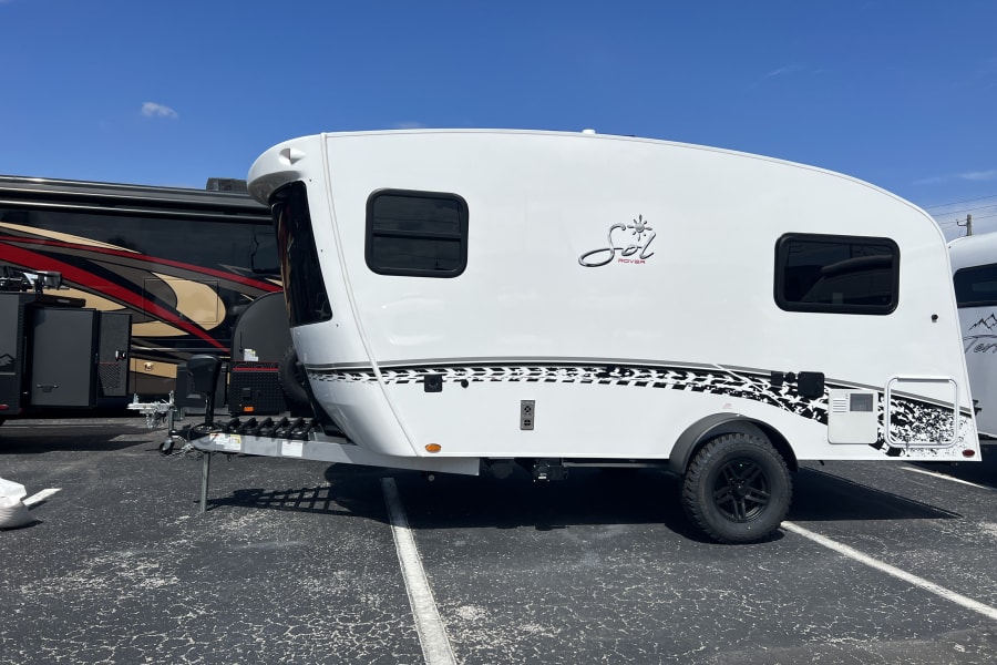 Compact Sol Rover travel trailer, ideal for your next RV rental adventure, parked on asphalt.