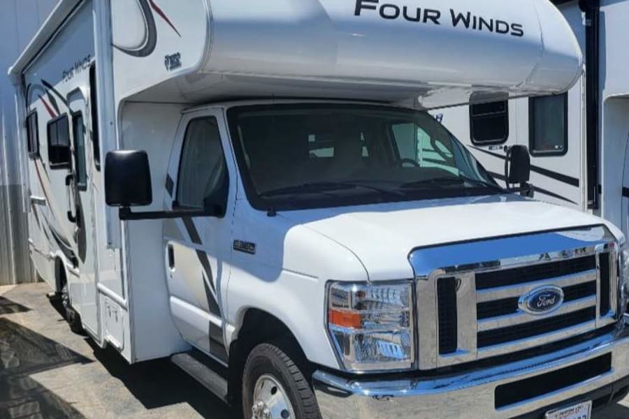 White Class C Four Winds RV parked outdoors on a sunny day, ideal for an rv rental.