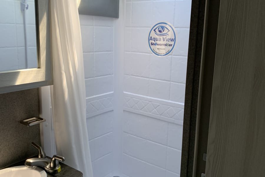 Clean RV rental bathroom with sink, vanity, and shower/tub combo, perfect for your next adventure.