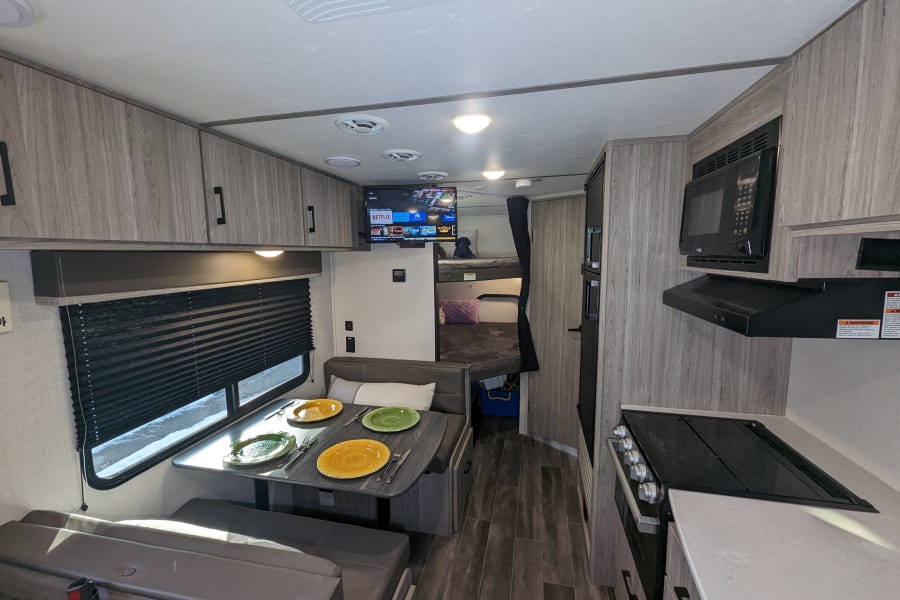 Full view of the dining area, kitchen, and full-sized bunk beds. 