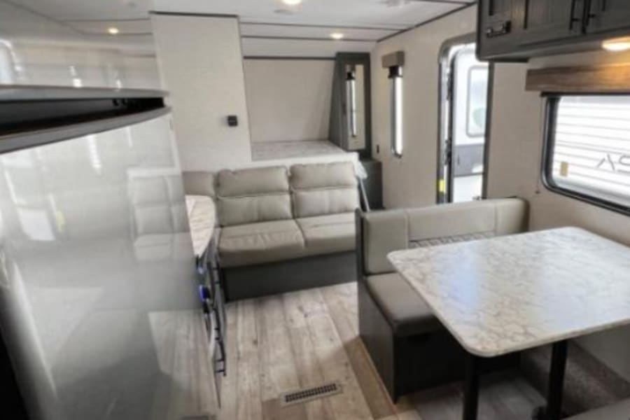 RV rental interior: Explore the spacious and modern living area, dinette, and cozy sleeping nooks for your next adventure.