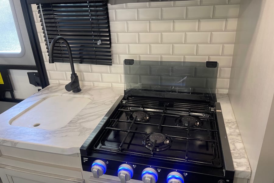 Three burner stovetop and sink. 