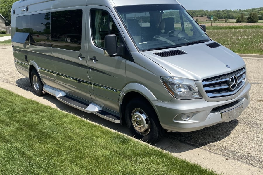 A sleek silver Mercedes Sprinter Winnebago camper van, perfect for your next RV rental journey, parked on a sunny day.