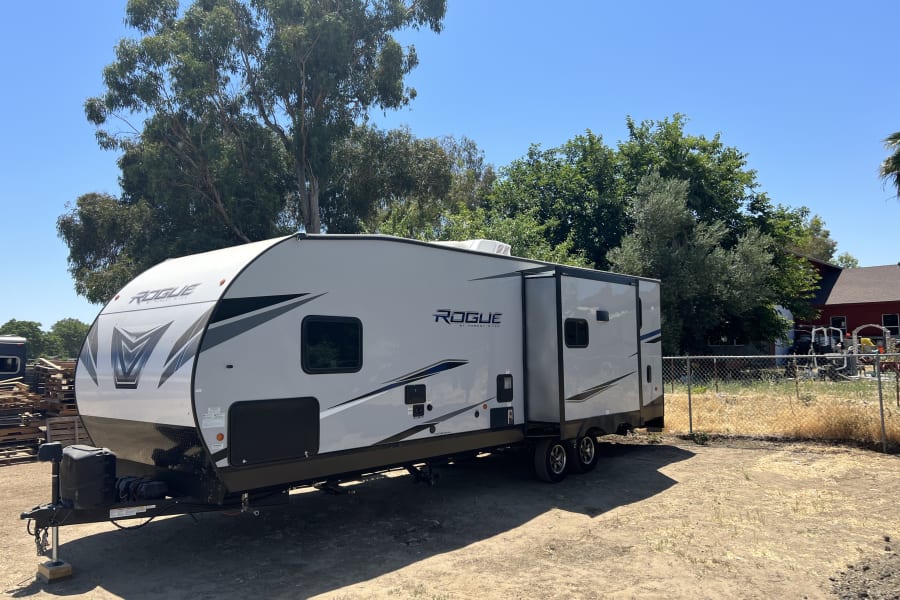 Spacious Forest River Rogue toy hauler RV rental parked on a sunny lot, ready for adventure.