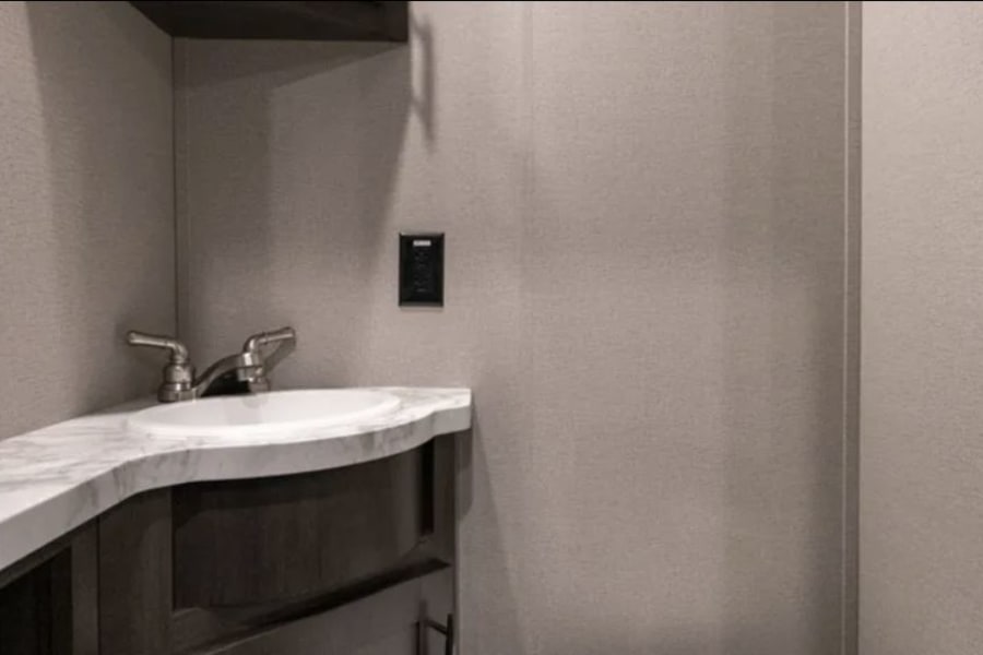 Secondary bathroom located in garage. It has a toilet & sink, no bath/shower.